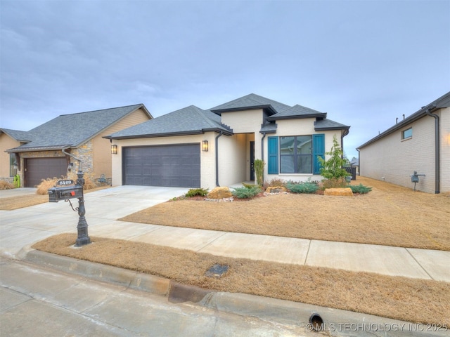 view of front of house with concrete driveway, roof with shingles, and an attached garage