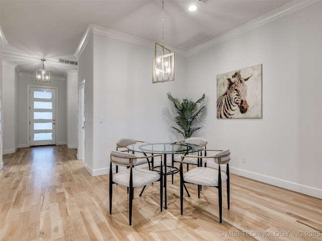 dining room with a chandelier, visible vents, baseboards, ornamental molding, and light wood finished floors