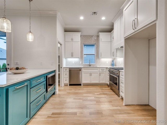 kitchen featuring visible vents, appliances with stainless steel finishes, light wood-type flooring, white cabinetry, and a sink