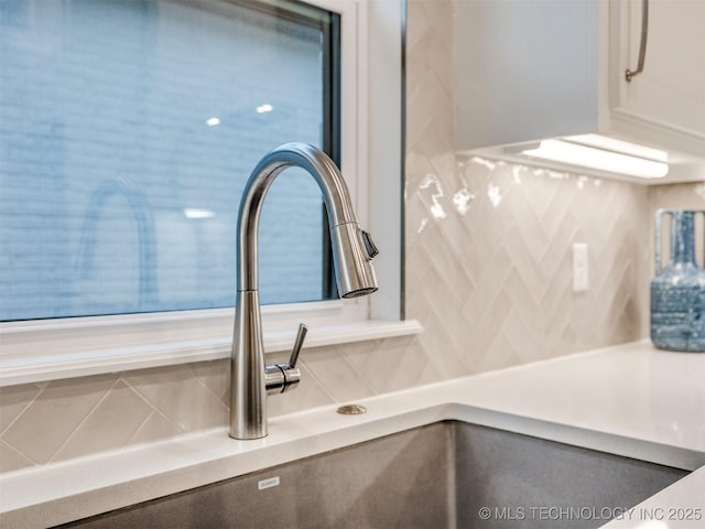 room details with light countertops, a sink, and white cabinetry