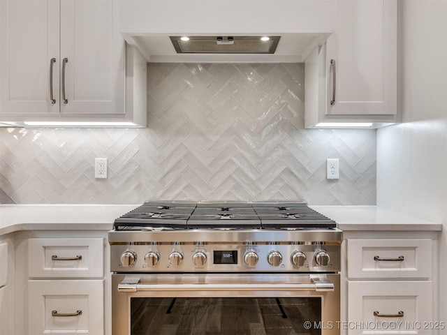 kitchen featuring white cabinets, premium range hood, light countertops, and high end stainless steel range