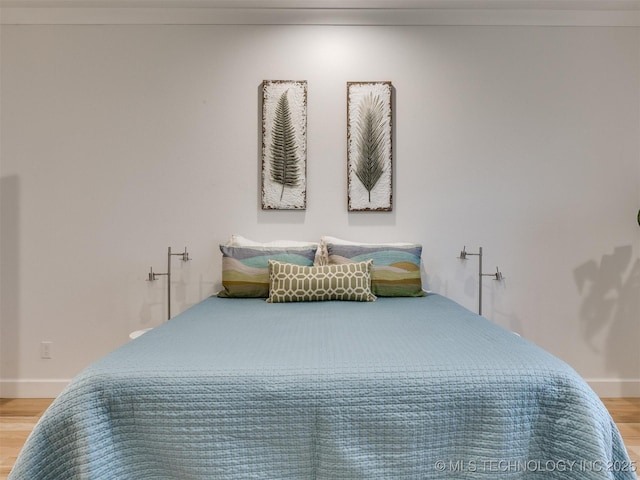 bedroom featuring wood finished floors and baseboards