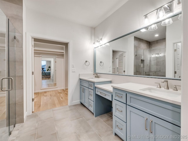 bathroom with a stall shower, tile patterned floors, baseboards, and vanity