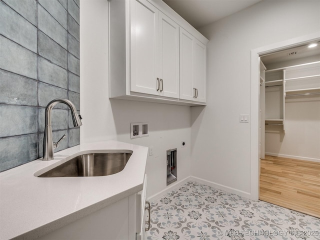 laundry room with hookup for an electric dryer, washer hookup, a sink, baseboards, and cabinet space