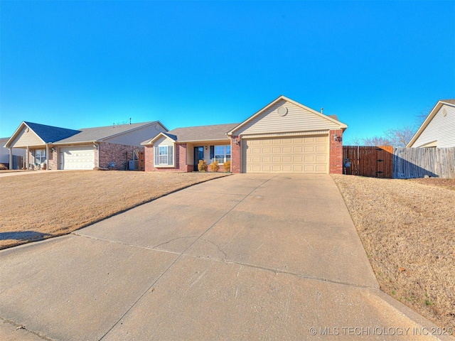 ranch-style house with concrete driveway, an attached garage, a gate, fence, and brick siding