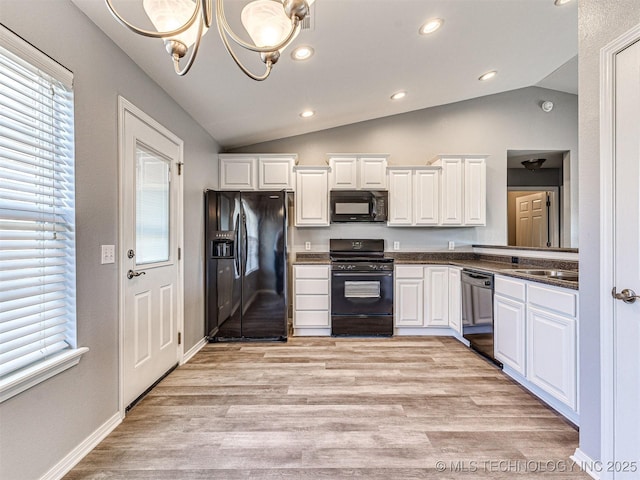 kitchen featuring light wood-style floors, dark countertops, vaulted ceiling, black appliances, and white cabinetry