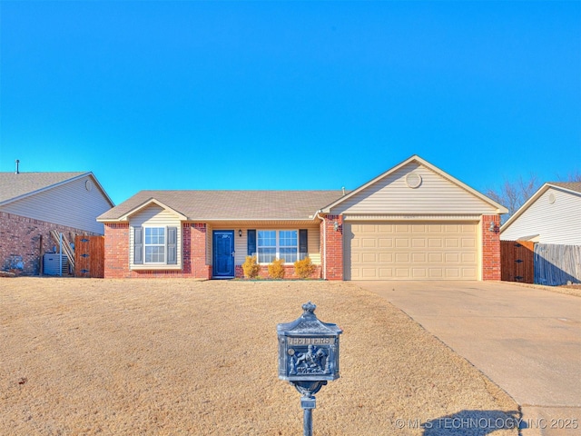 single story home featuring a garage, concrete driveway, brick siding, and fence