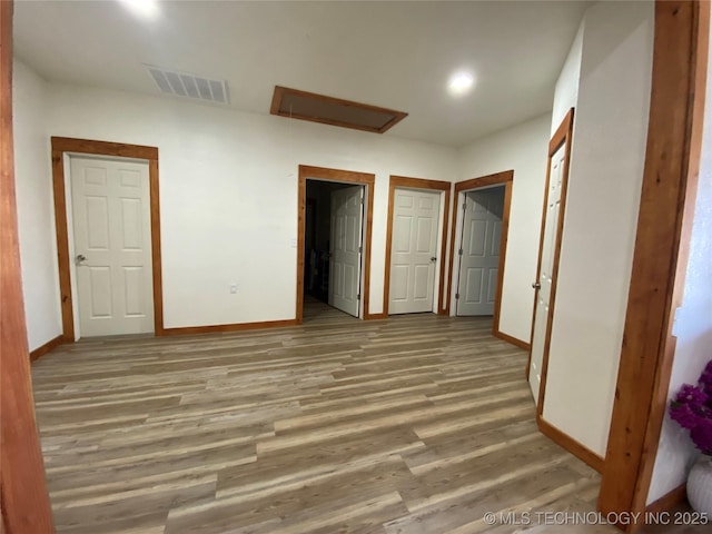 unfurnished bedroom with wood finished floors, visible vents, and baseboards