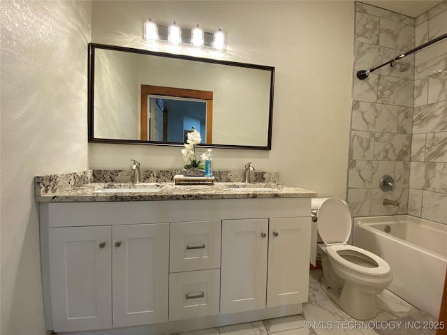 full bathroom with marble finish floor, double vanity, a sink, and toilet