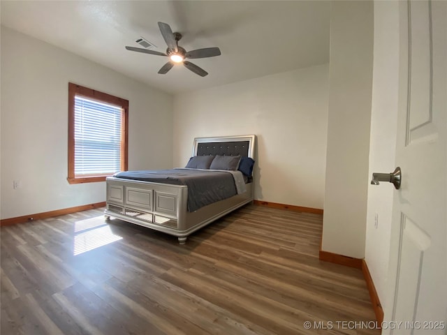 bedroom featuring baseboards, visible vents, and wood finished floors