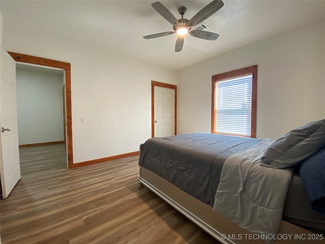 bedroom featuring a ceiling fan, baseboards, and wood finished floors