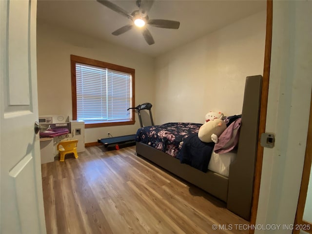 bedroom featuring a ceiling fan, baseboards, and wood finished floors