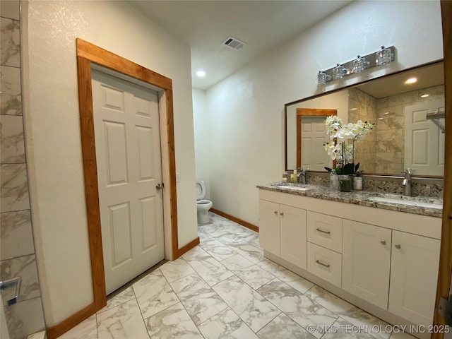 bathroom featuring marble finish floor, double vanity, a sink, and visible vents