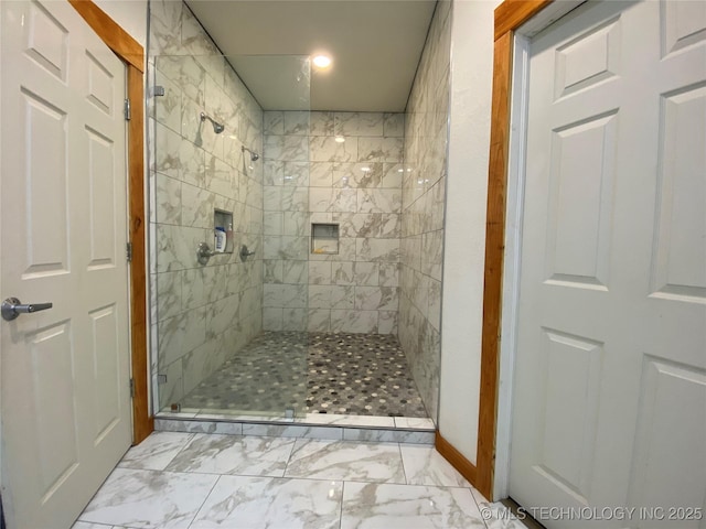 bathroom with a stall shower and marble finish floor