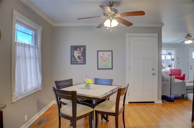 dining area with baseboards, light wood-style floors, visible vents, and crown molding