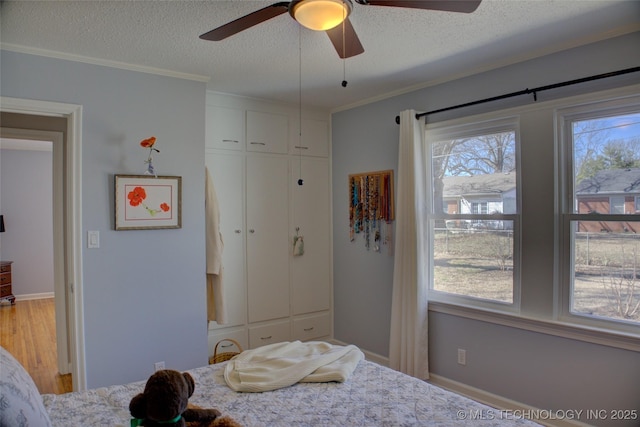 bedroom featuring ornamental molding, a closet, a textured ceiling, and wood finished floors