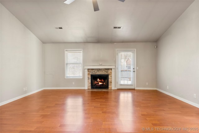 unfurnished living room with light wood-style flooring, a fireplace, visible vents, and baseboards