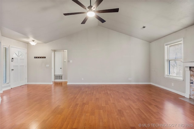 unfurnished living room with baseboards, visible vents, a stone fireplace, and light wood finished floors