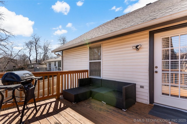 wooden terrace with an outdoor living space and grilling area