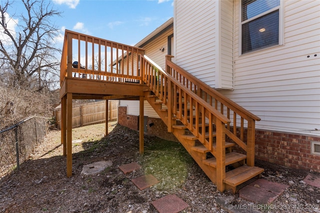 wooden terrace featuring a fenced backyard and stairway