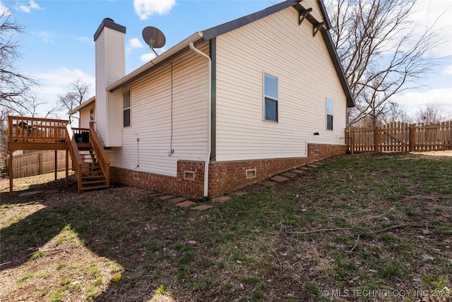 view of side of home with stairs, a deck, crawl space, and fence