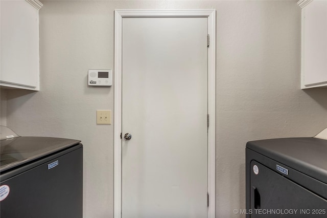 laundry room with independent washer and dryer and cabinet space