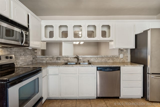 kitchen with appliances with stainless steel finishes, a sink, and white cabinetry