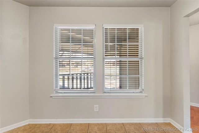 empty room featuring tile patterned floors and baseboards