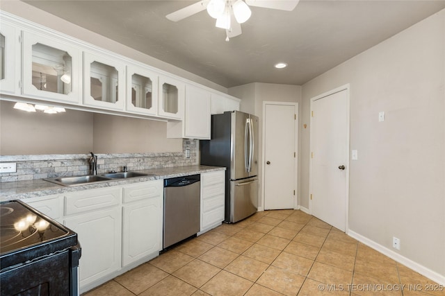 kitchen featuring stainless steel appliances, white cabinets, a sink, and decorative backsplash