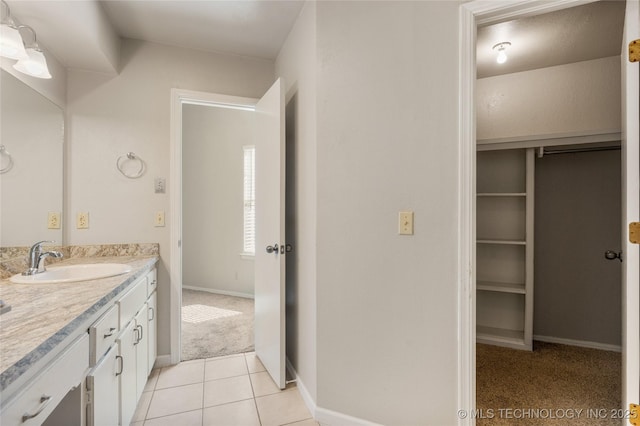 bathroom featuring tile patterned flooring, vanity, and baseboards