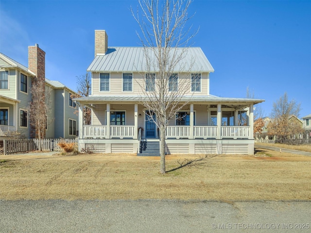 view of front of property featuring metal roof, a porch, a standing seam roof, and a chimney