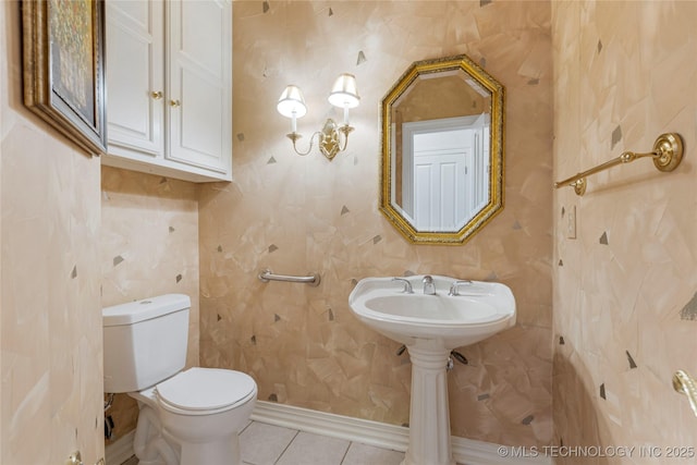 bathroom with tile patterned floors, toilet, and baseboards