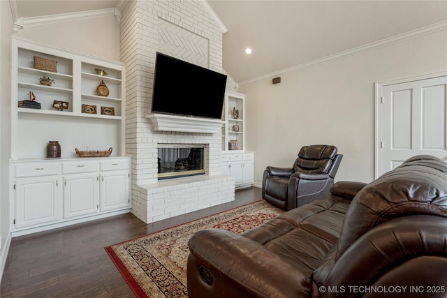 living room with dark wood-style floors, lofted ceiling, a brick fireplace, and crown molding