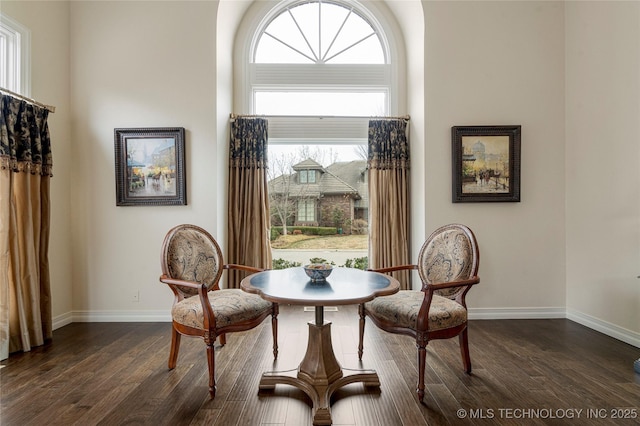 sitting room with dark wood finished floors and baseboards