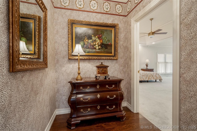 hallway featuring baseboards, dark wood finished floors, and wallpapered walls