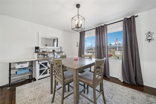 dining room featuring a chandelier, wainscoting, and wood finished floors