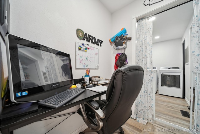 office featuring visible vents, wood finished floors, and washer / dryer