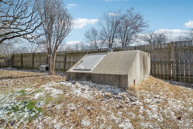 view of storm shelter featuring fence