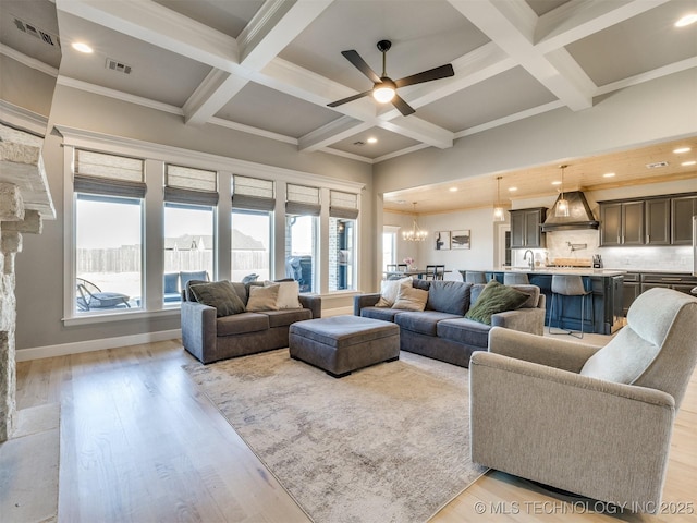 living area with beam ceiling, light wood-type flooring, coffered ceiling, and visible vents