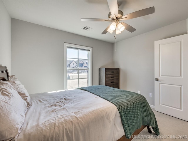 bedroom with visible vents, a ceiling fan, and light colored carpet