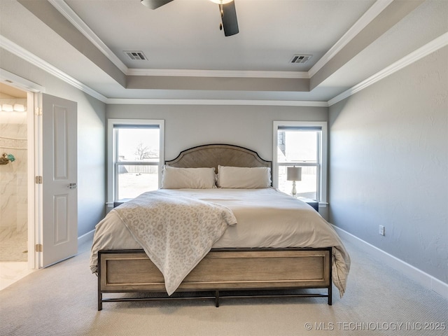 bedroom with a tray ceiling, multiple windows, and visible vents