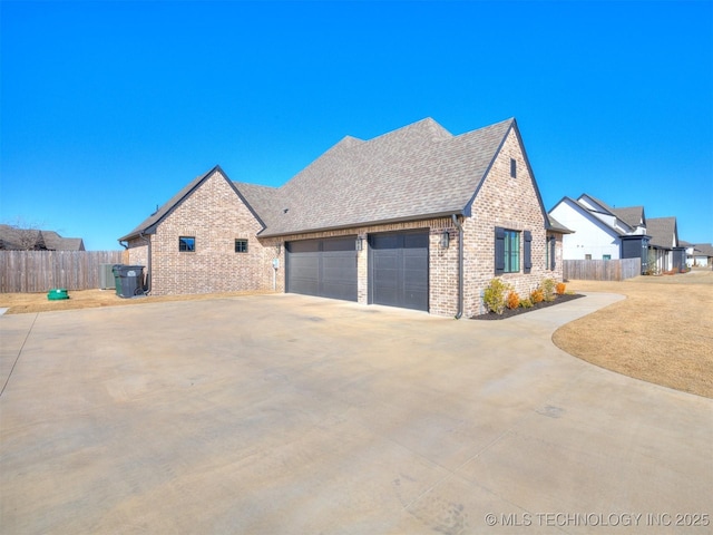 view of property exterior with driveway, fence, and brick siding