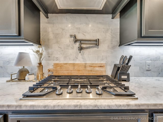 interior details featuring tasteful backsplash and stainless steel gas stovetop