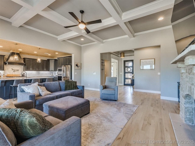 living area with light wood finished floors, coffered ceiling, and beamed ceiling