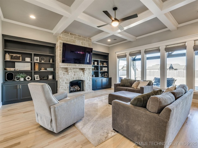 living room featuring light wood-type flooring, a fireplace, coffered ceiling, and beam ceiling