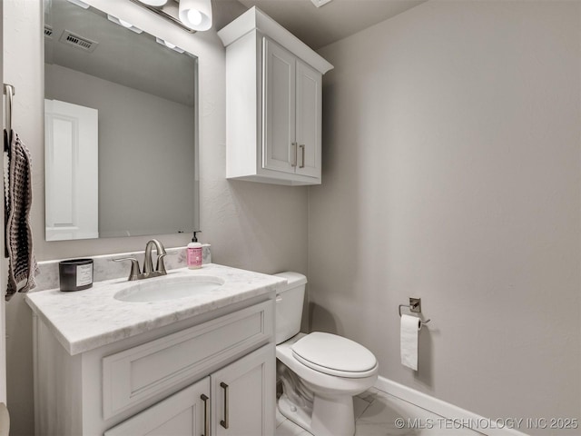 half bathroom featuring toilet, vanity, visible vents, and baseboards