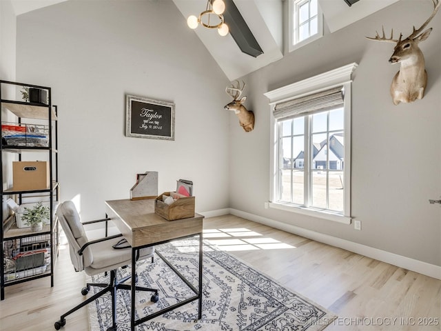 home office featuring high vaulted ceiling, a wealth of natural light, and wood finished floors