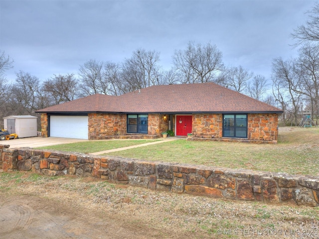 view of front of house featuring a garage, an outdoor structure, stone siding, concrete driveway, and a front yard