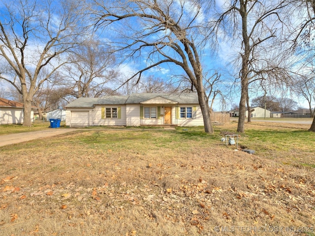 view of front of house featuring a front lawn, driveway, and an attached garage