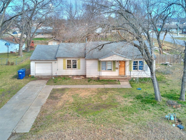 ranch-style house with a front yard, fence, driveway, and an attached garage